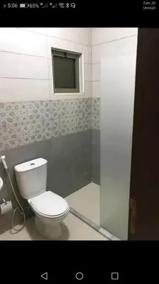 a bathroom with a toilet and a window at في ظلال الطبيعه in Aqaba