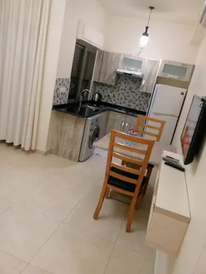 a kitchen with a sink and a table and chairs at في ظلال الطبيعه in Aqaba