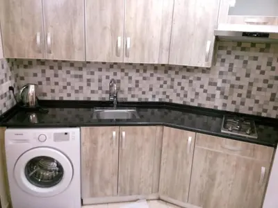 a kitchen with a sink and a washing machine at في ظلال الطبيعه in Aqaba