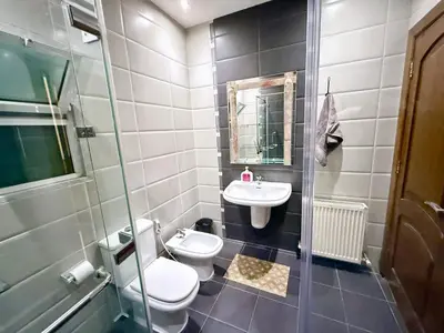 a bathroom with a toilet and a sink at Fully Equipped 3BR Apt in Family-Friendly Building in Amman