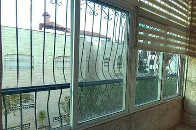 a window with a view of a building at Fully Equipped 3BR Apt in Family-Friendly Building in Amman