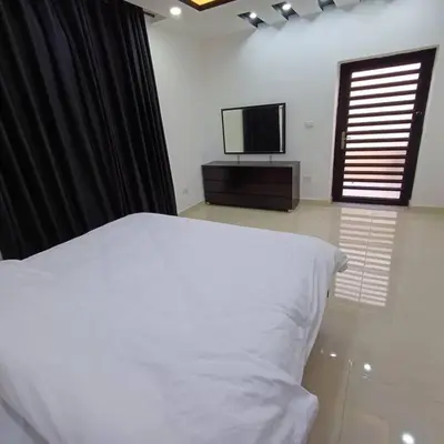 a bedroom with a bed and a flat screen tv at Laperla luxury family apartment one in Amman