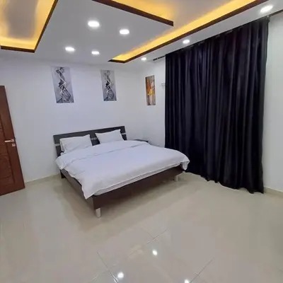 a bedroom with a bed and a black curtain at Laperla luxury family apartment one in Amman