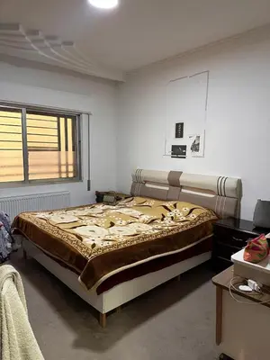 a bedroom with a large bed and a window at كريستال in Amman