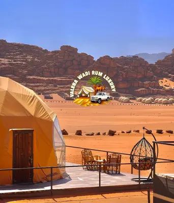 a tent in the desert with a sign in the background at Valera wadi rum Luxury in Wadi Rum