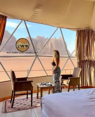 a little girl standing in front of a window at RUM BUBBLES VIEW lUXURY CAMP in Wadi Rum