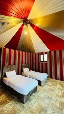 a room with two beds in a striped wall at Wadi Rum Camp AW in Disah