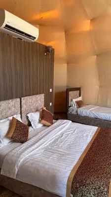 a bedroom with two beds with white sheets at Welcome to Wadi Rum in Wadi Rum