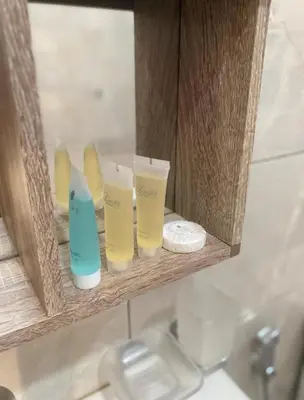 a shelf with three cups and a mirror in a bathroom at Welcome to Wadi Rum in Wadi Rum