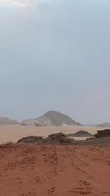 a desert with rocks and mountains in the distance at Desert Magic Camp in Wadi Rum