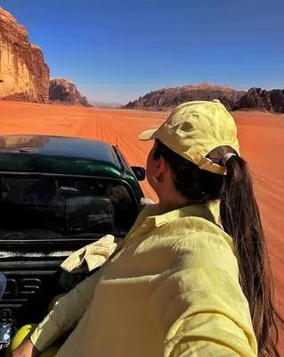 a woman driving a truck in the desert at Desert Magic Camp in Wadi Rum