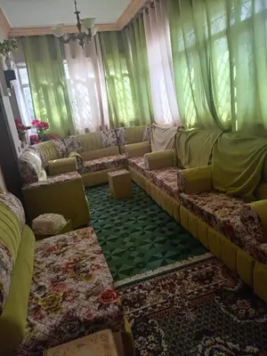a living room with green curtains and a couch at Hello hostel in Amman