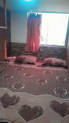 a bed with hearts on it with a window at Gorge home in Amman