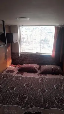 a large bed in a room with a window at Gorge home in Amman