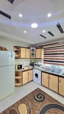 a kitchen with a white refrigerator and a dishwasher at water house in Al Quwaysimah
