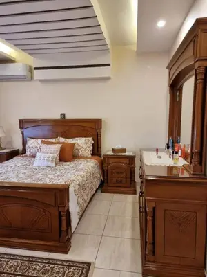 a bedroom with a wooden bed and a sink at water house in Al Quwaysimah