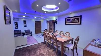 a dining room with a wooden table and chairs at water house in Al Quwaysimah