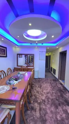 a dining room with a table and a blue ceiling at water house in Al Quwaysimah