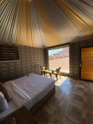 a bedroom with a bed and a table in it at wadi Rum Mohammed in Wadi Rum