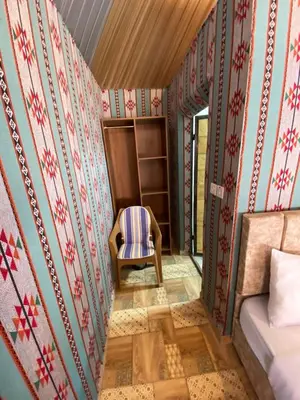 a room with a bed and a chair in it at wadi Rum Mohammed in Wadi Rum