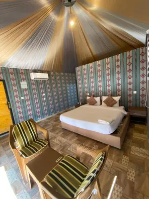 a bedroom with a bed and a couch and a chair at wadi Rum Mohammed in Wadi Rum