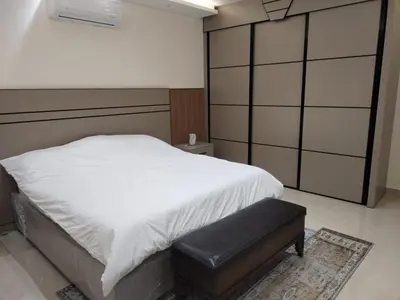 a bedroom with a white bed and a black stool at Amman Sweet-Home - 2 bedrooms Apartment in Amman