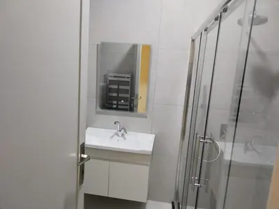 a white bathroom with a sink and a shower at Amman Sweet-Home - 2 bedrooms Apartment in Amman