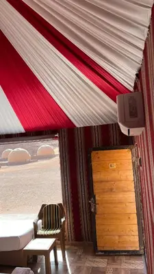 a tent with a door and a television in a room at Monica Wadi Rum in Wadi Rum
