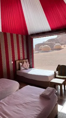 two beds in a room with a view of the desert at Monica Wadi Rum in Wadi Rum