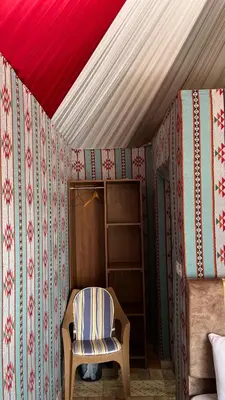 a chair sitting in a room with a ceiling at Monica Wadi Rum in Wadi Rum