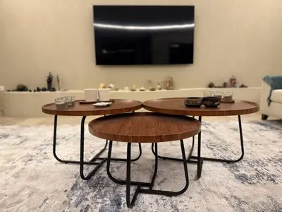 two round tables in a living room with a tv at Bargos Cave in Amman