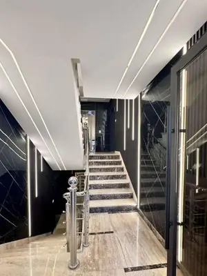 a staircase in a building with black walls and ceilings at Bargos Cave in Amman