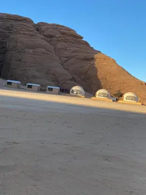 a desert with a rocky mountain in the background at Sela wadi rum in Wadi Rum