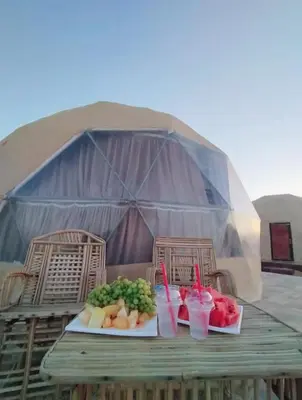 a table with two plates of food on a tent at Sela wadi rum in Wadi Rum