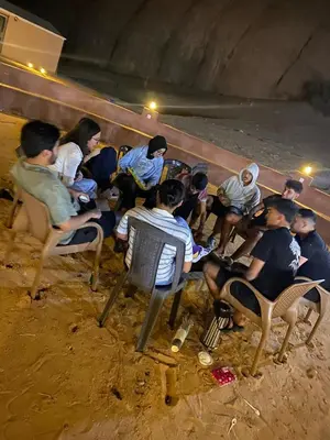 a group of people sitting in chairs on the beach at Sela wadi rum in Wadi Rum