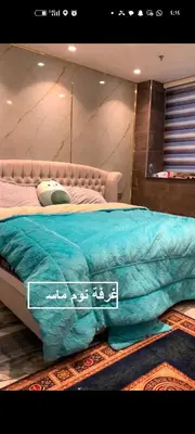 a bedroom with a bed with a blue comforter at شقه دوبلكس داماك العبدلي in Amman