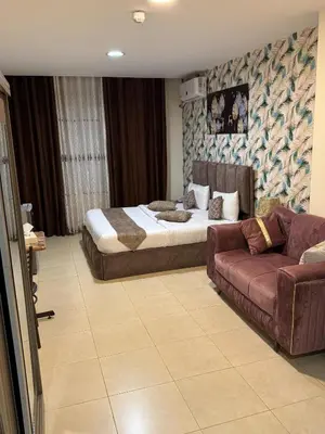 a bedroom with a bed and a couch at Al-RAYAN HOTEL SUITES in Amman