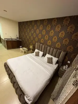 a bedroom with a large bed with white sheets at Al-RAYAN HOTEL SUITES in Amman