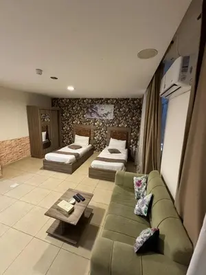 a living room with a couch and two beds at Al-RAYAN HOTEL SUITES in Amman