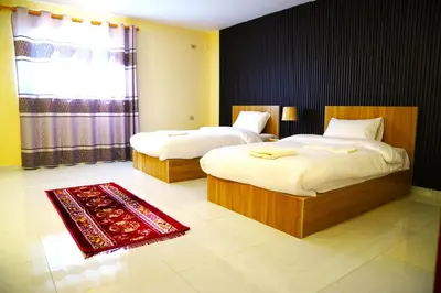 a bedroom with two beds and a red rug at Uncle Ali hotel in Wadi Musa