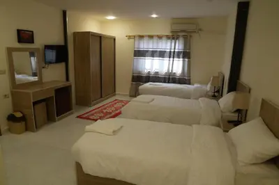 a living room with three beds and a television at Uncle Ali hotel in Wadi Musa