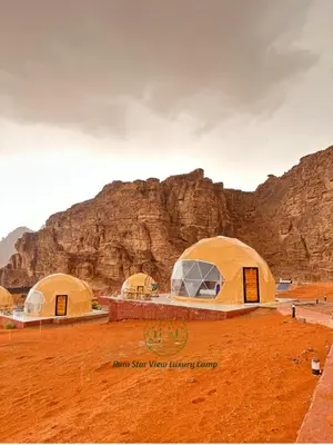 three tents in the desert with a mountain in the background at RUM STAR VIEW BUBBLES lUXURY CAMP in Wadi Rum
