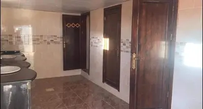 a bathroom with two brown doors and two sinks at Wadi rum camp with tour in Wadi Rum