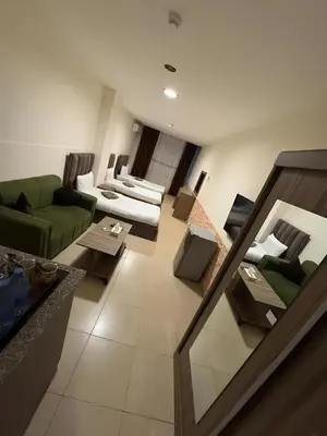 a living room with a green couch and chairs at Ryan Hotel Suites in Amman