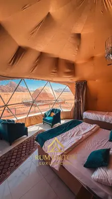 a large bed in a tent with a large window at RUM HiLTON lUXURY CAMP in Wadi Rum