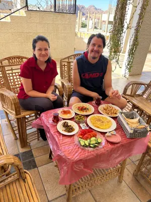 a man and woman sitting at a table with food at Nora Bedouin Home in Petra