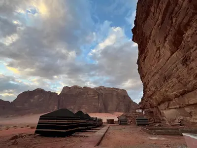 a group of tents in the desert with a mountain at Desert Rock Wadi Rum in Wadi Rum