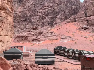a row of domes in the desert near a mountain at Desert Rock Wadi Rum in Wadi Rum