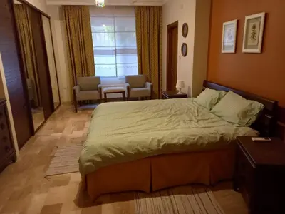 a bedroom with a bed and a table and chairs at Happy Family Home with Spacious Garden in Amman