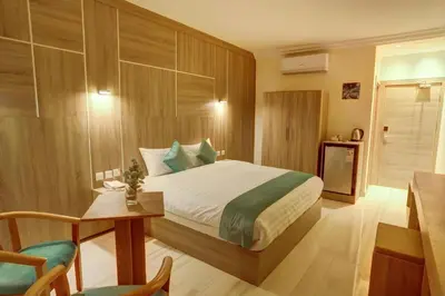 a bedroom with a bed and a table and chairs at Turquoisejo Hotel in Aqaba
